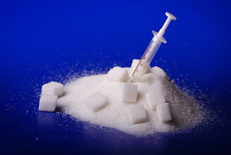 Insulin injection white a pile of sugar