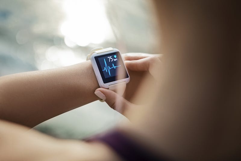 Woman Looking At Her Smart Watch for a pulse trace