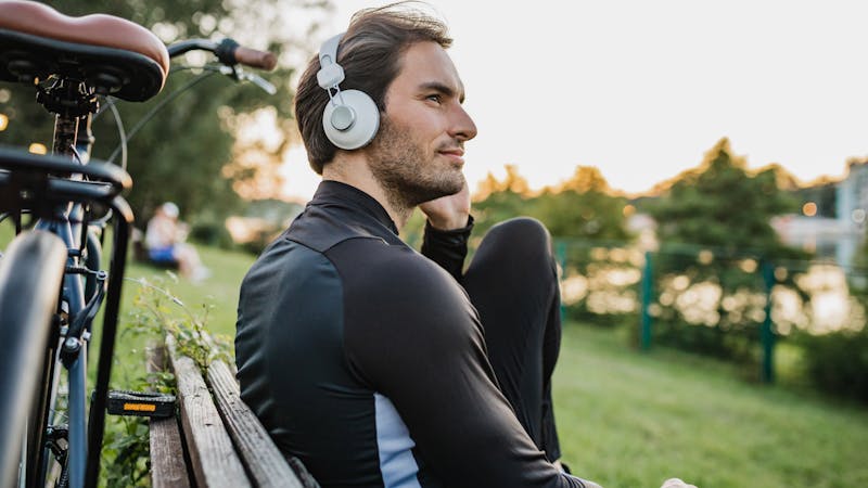 Young sports guy is taking a break from cycling by the lake