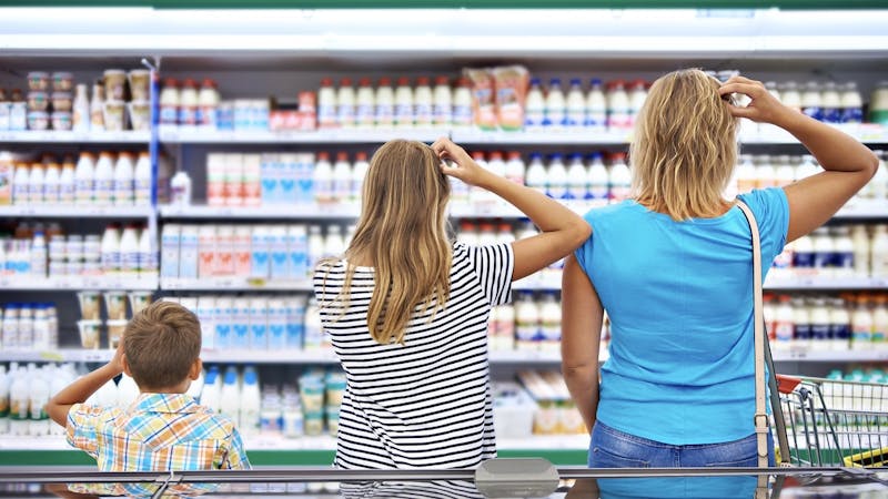 Mother and children are choosing dairy products in shop