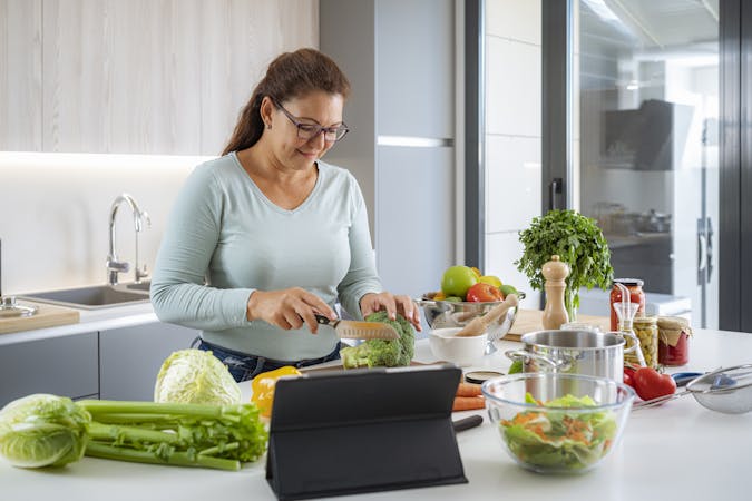 Happy woman cooking healthy vegan food