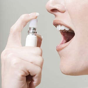 Woman spraying breath freshener