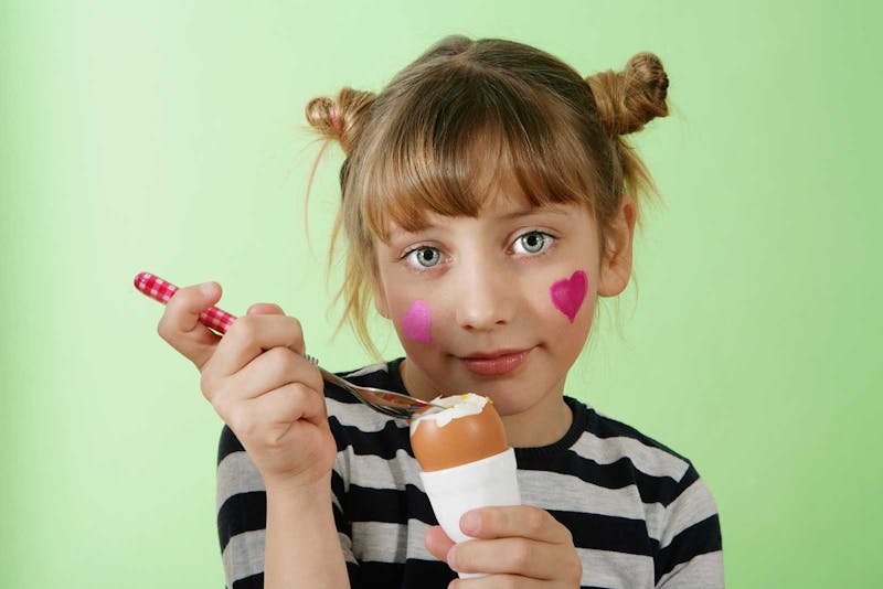 Kid eating an egg