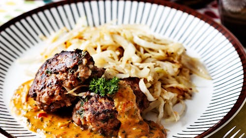 Keto hamburger patties with creamy tomato sauce and fried cabbage