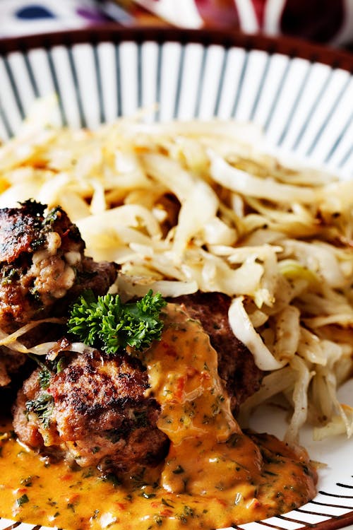 Keto hamburger patties with creamy tomato sauce and fried cabbage