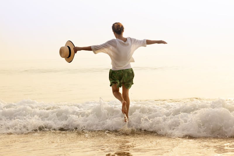 Happy woman with straw hut on beach