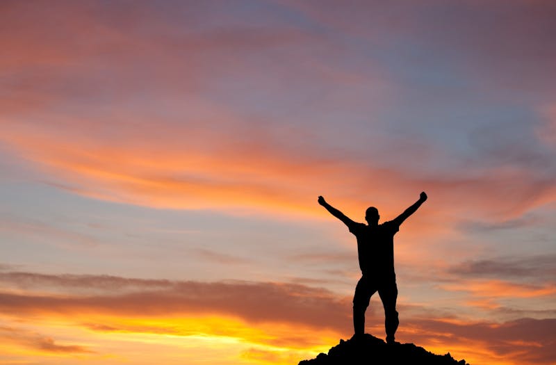 Silhouette of Man Lifting Arms in Joy