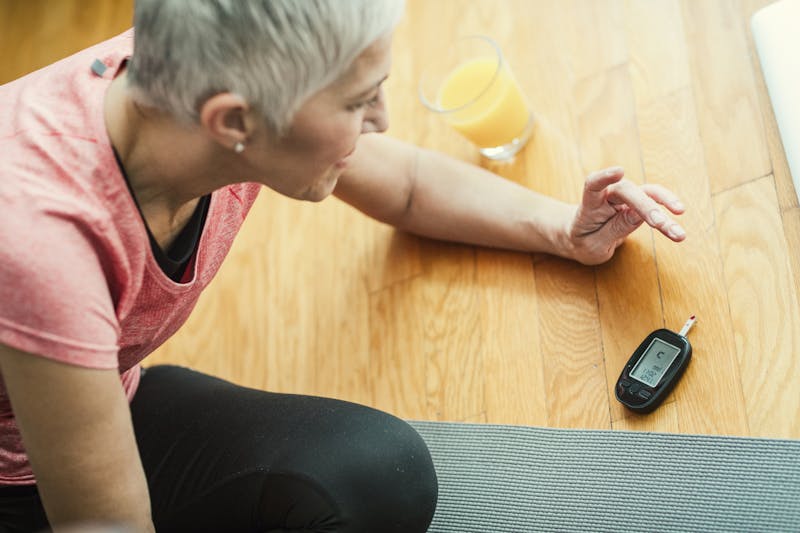 Mature Woman Doing Blood Sugar Test after exercise.
