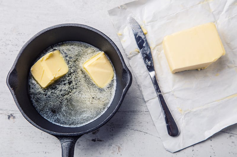 Butter. Pieces of butter in the hot pan top view