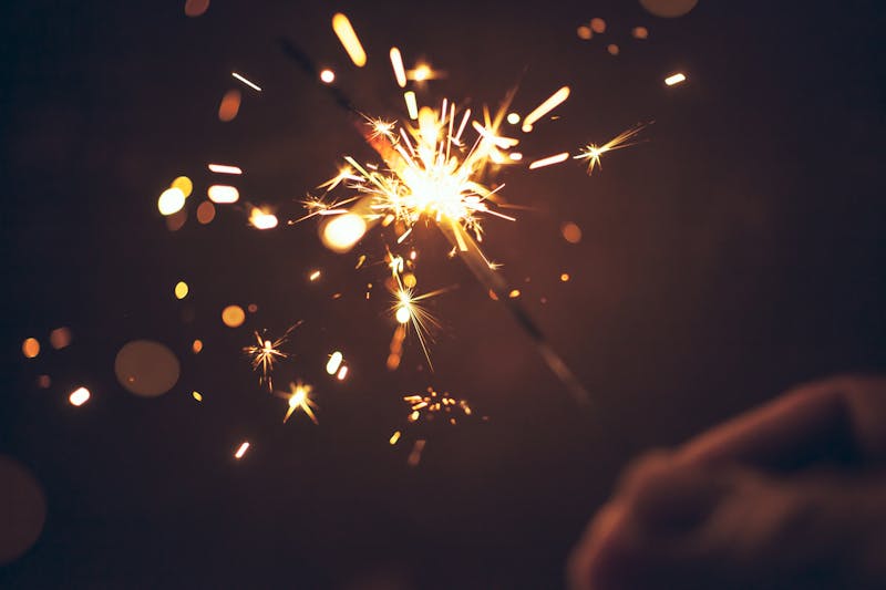 Person celebrating at night by holding sparkler – New Year Christmas Celebration