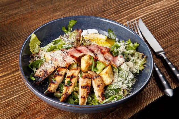 Chicken Salad. Chicken Caesar Salad. Caesar Salad with grilled chicken on plate. Grilled chicken breasts and fresh salad in plate