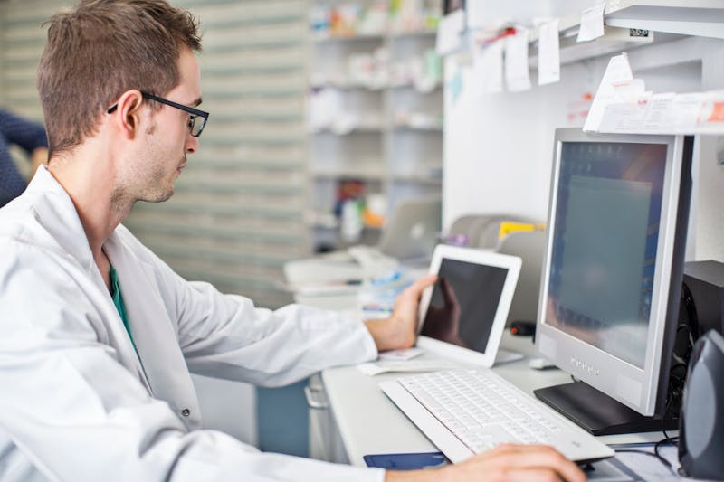 Male pharmacist working at his desk
