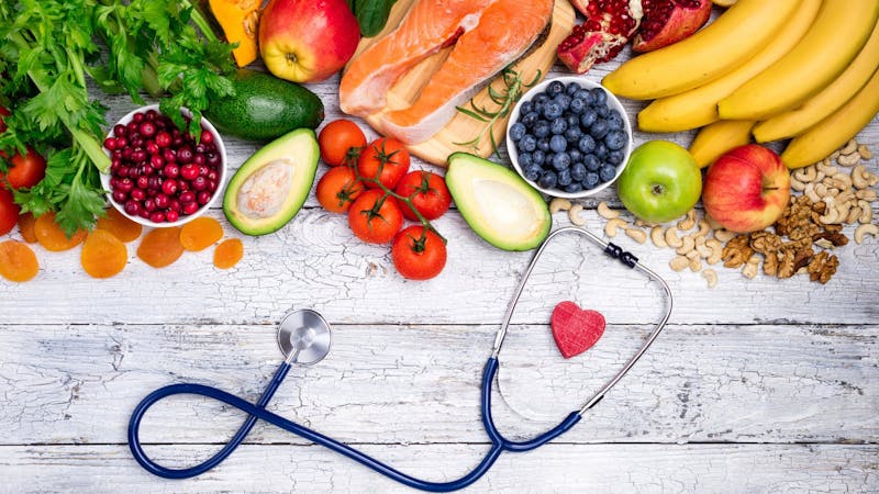 An image of fruits, vegetables, and a stethoscope 