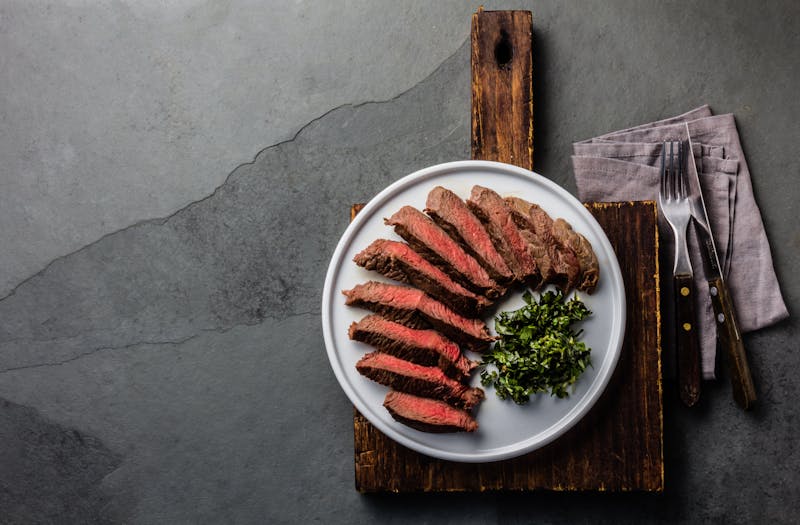 Medium rare beef steak on white plate