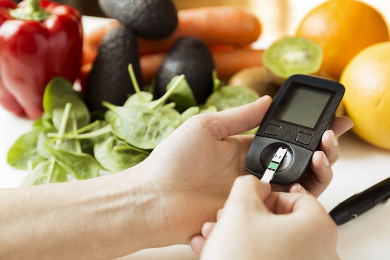 Diabetes monitor, diet and healthy food eating nutritional concept with clean fruits and vegetables with diabetic measuring tool kit