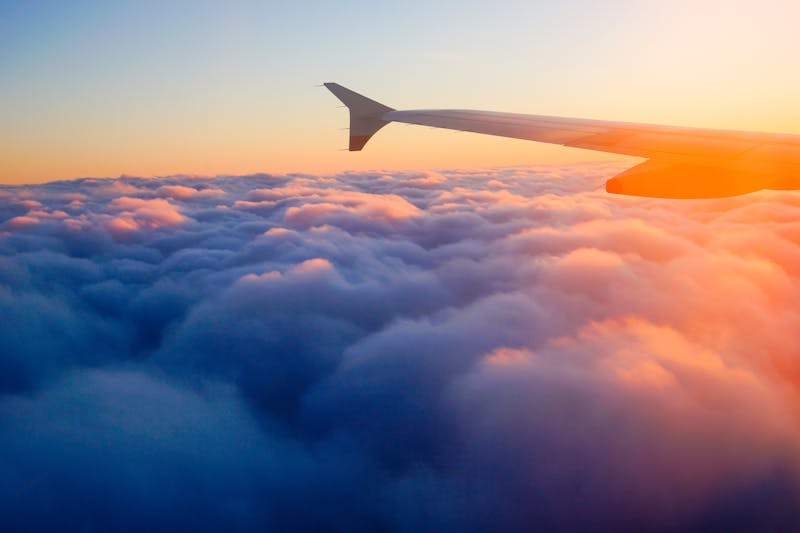 Airplane Wing in Flight from window, sunset sky