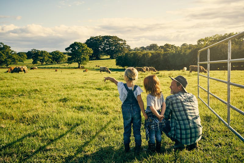 male farmer and his two kids on their farm