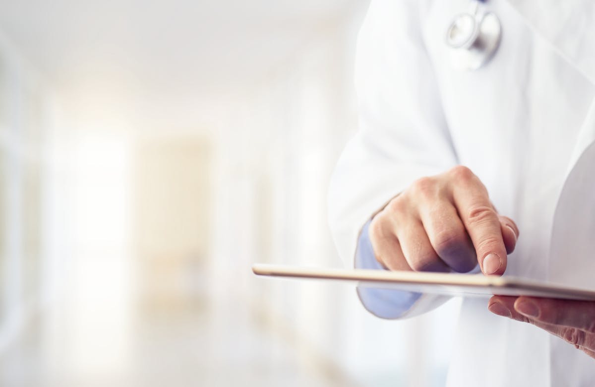 Male doctor using his digital tablet