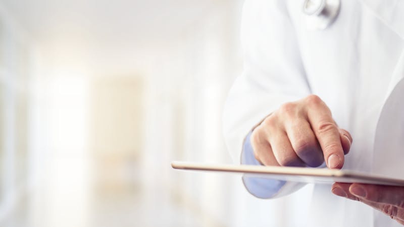 Male doctor using his digital tablet
