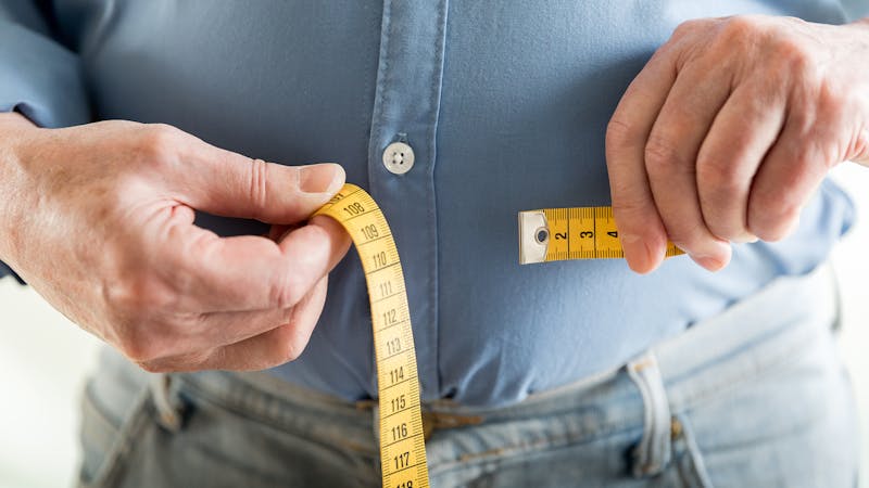 Man measuring his belly