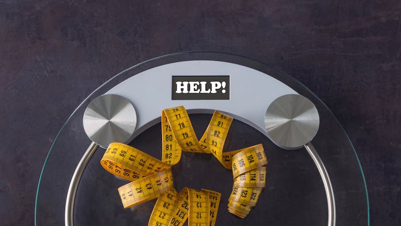 Weight scale with a measuring tape. Concept- lifestyle, sports and diet for weight loss. Copy space. On the measuring scale written word - HELP!