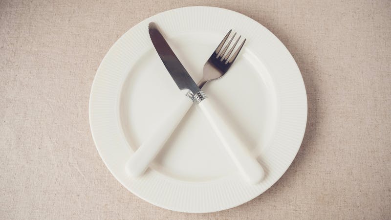 white plate with knife and fork, Intermittent fasting concept, ketogenic diet, weight loss