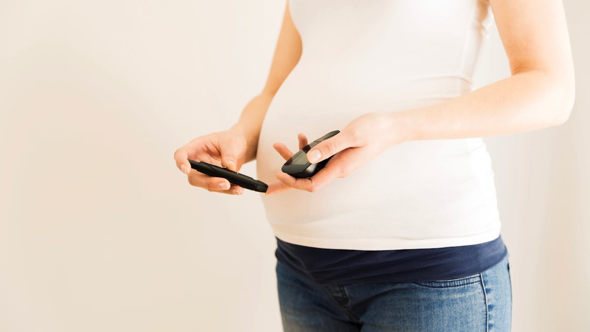 Pregnant woman checking blood sugar level.