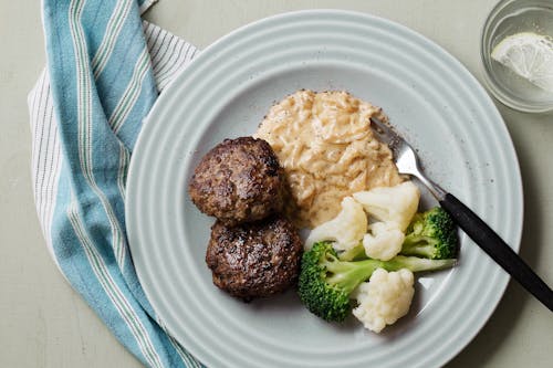 Beef patties with creamy onion gravy and broccoli