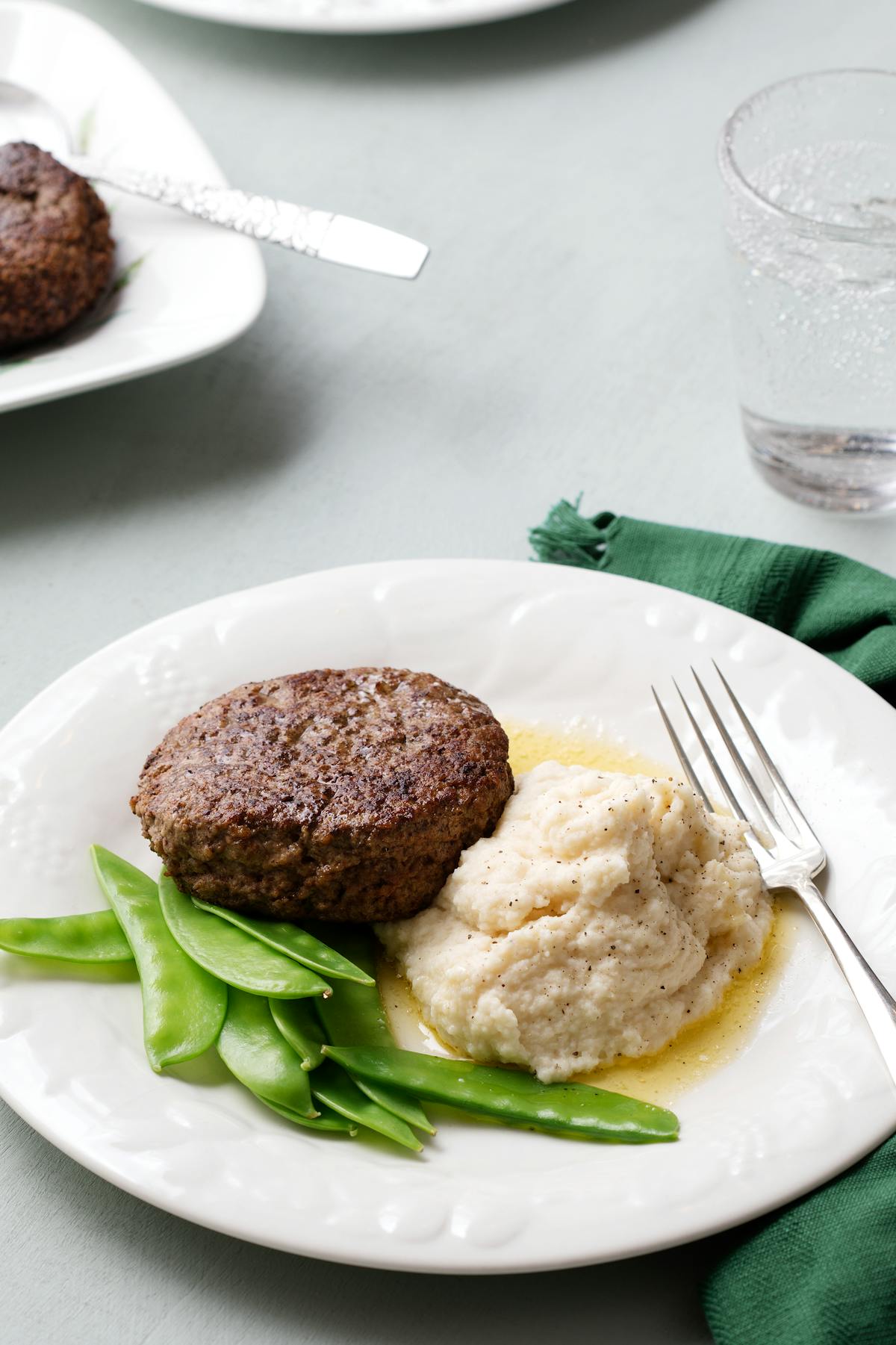 Veal burger with celery root mash and sugar snaps