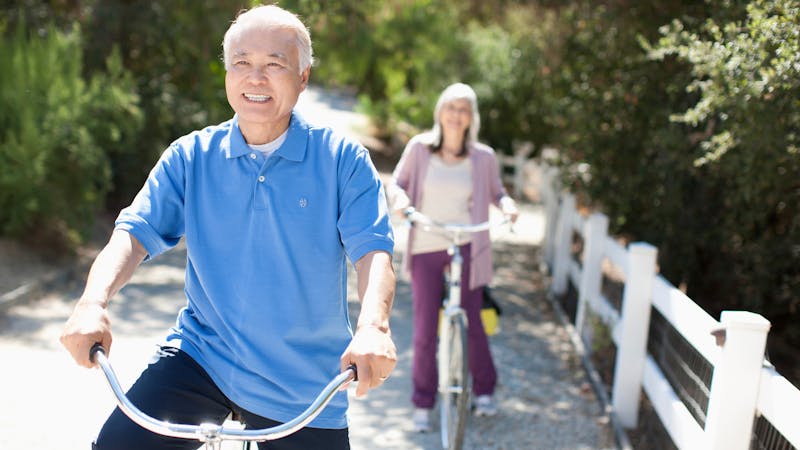 Smiling older couple riding bicycles