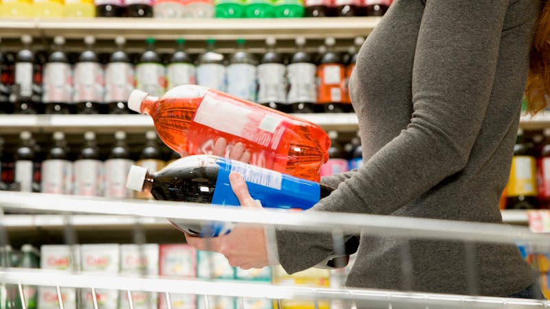 Woman comparing ingredients on soda bottle