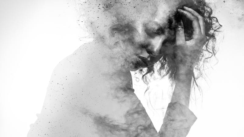 Unhappy woman’s form double exposed with paint splatter effect