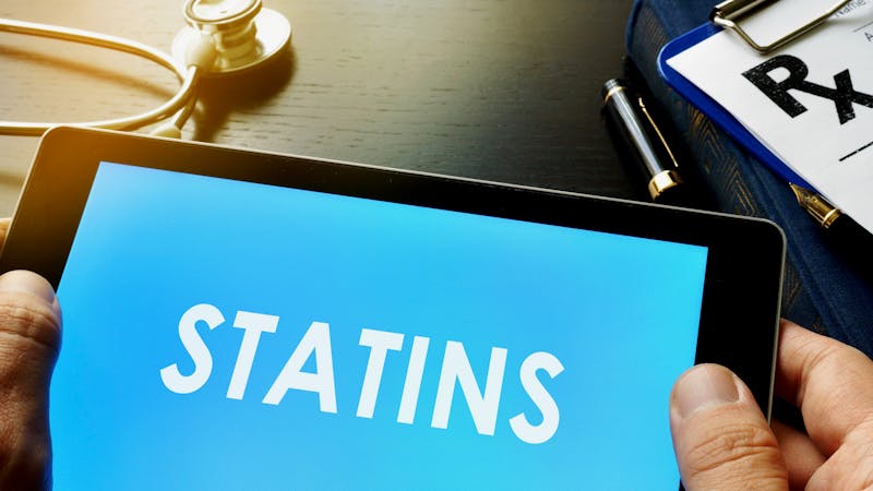 Doctor holding a tablet with word statins.