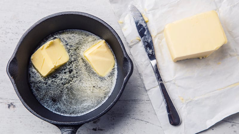 Butter. Pieces of butter in the hot pan top view