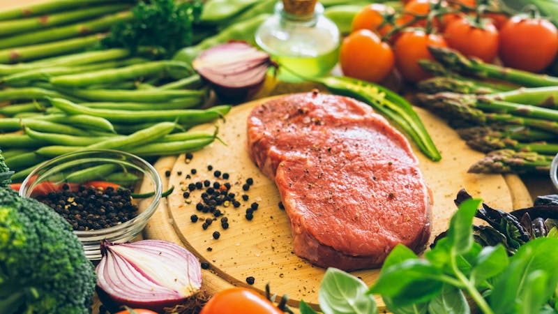 Raw rib eye steak with vegetables