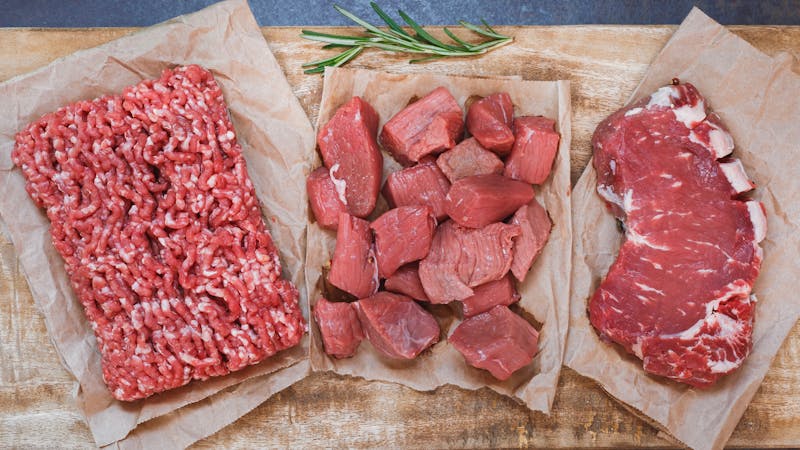 Fresh raw angus beef meat, whole, ground and chopped on parchment paper