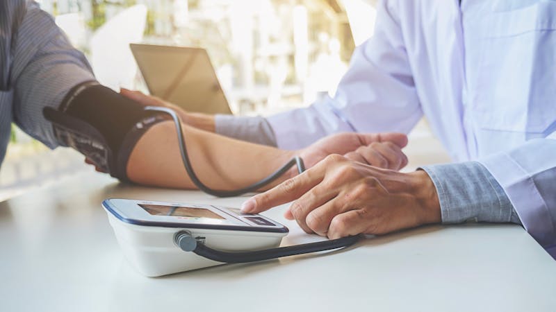 healthcare, hospital and medicine concept - doctor and patient measuring blood pressure.