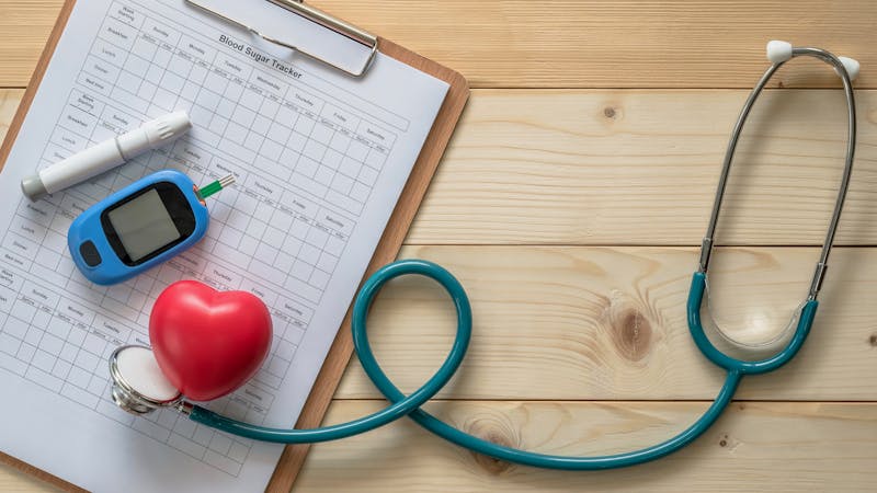 World diabetes day, National American diabetic awareness month concept with blood drop examination tool kit, blood sugar tracker record and heart with doctor’s stethoscope