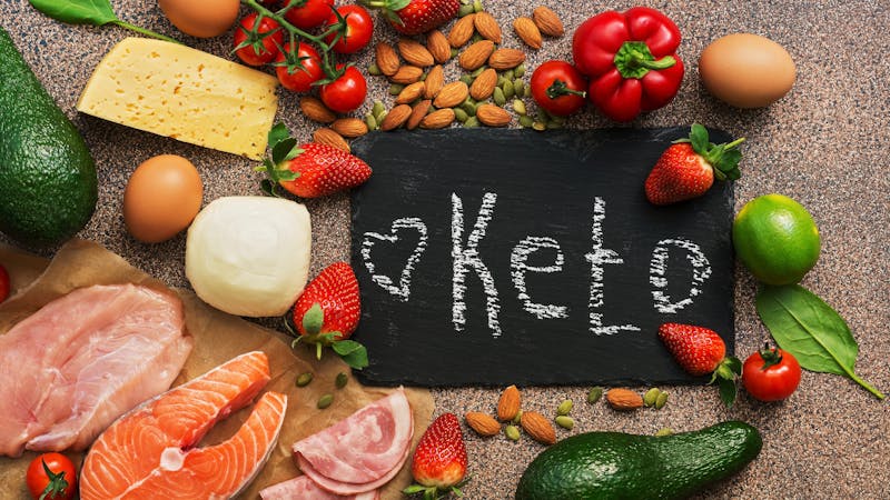 Keto diet food. Healthy low carbs products.Keto diet concept. Vegetables, fish, meat, nuts, seeds, strawberries, cheese. Top view. Signboard.