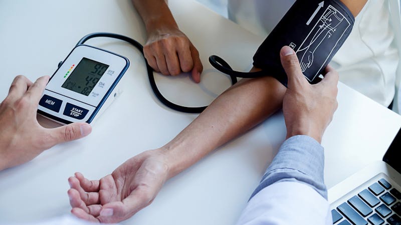 healthcare, hospital and medicine concept - doctor and patient measuring blood pressure.