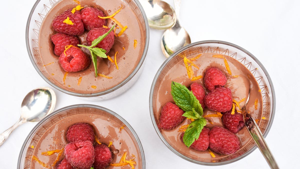 Low-carb chocolate pudding with raspberries and orange zest