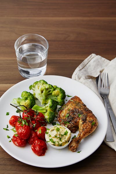 Roasted chicken legs and cherry tomatoes with garlic butter