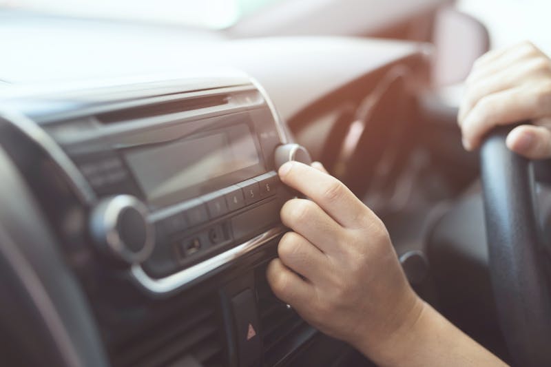 close up hand open car radio listening. Car Driver changing turning button Radio Stations on His Vehicle Multimedia System. Modern touch screen Audio stereo System. transportation and vehicle concept