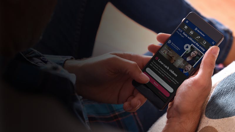 Adult man sitting on a sofa using a smartphone