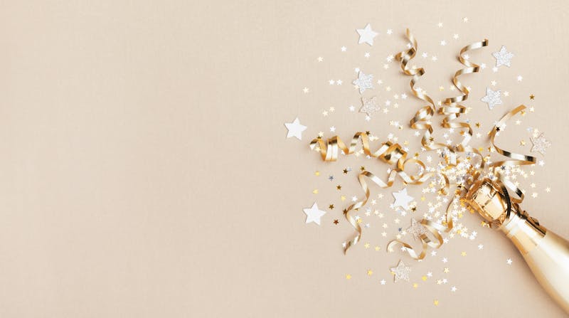 Celebration background with golden champagne bottle, confetti stars and party streamers. Christmas, birthday or wedding concept. Flat lay.