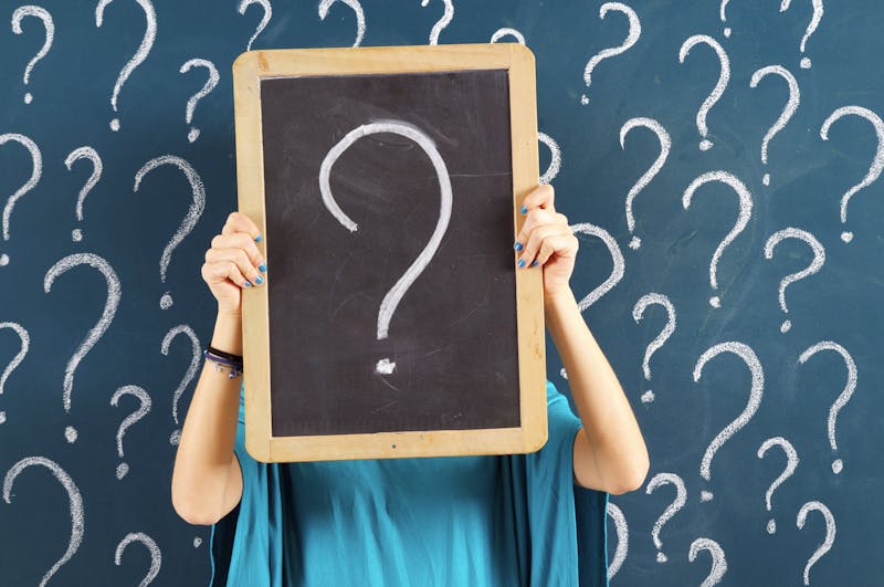 Woman holding chalkboard with question mark