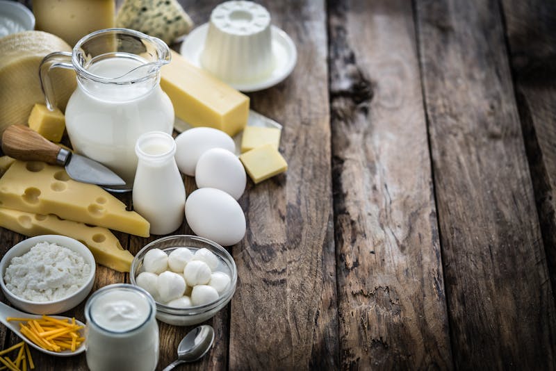 Assortment of dairy products on rustic wooden table. Copy space