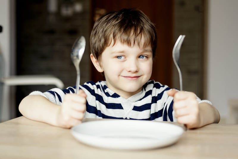 Happy little boy waiting for dinner.