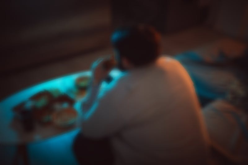Overweight man eating a burger