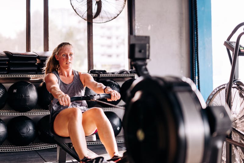 Cross training and rowing on the machine in gym